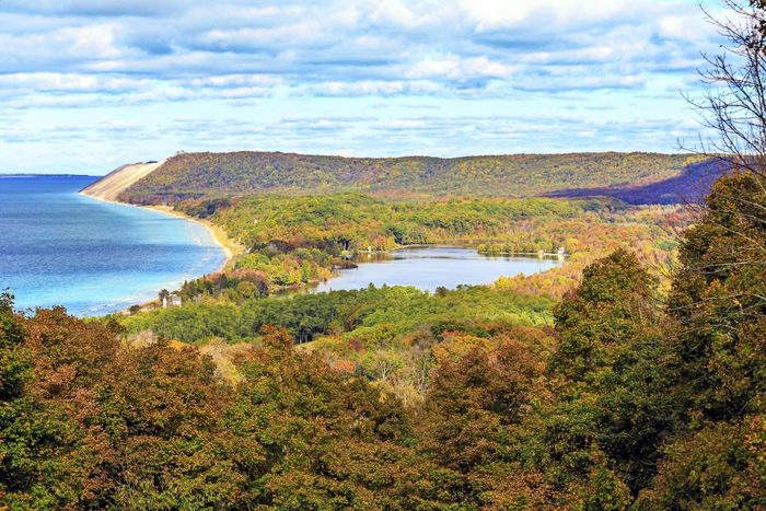 A view of South Bar Lake and Lake Michigan, as seen from Empire Bluff Trail. Sleeping Bear Plateau, part of Sleeping Bear Dunes is a dominant part of the scene. South Manitou Island can be seen in the distance.