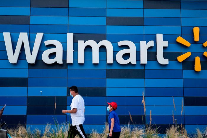 A man and child wearing facemasks walk in front of a Walmart store in Washington, DC on July 15, 2020. - Walmart will require shoppers to wear face masks starting next week, the US retail giant announced on July 15, joining an increasing number of businesses in mandating the protection amid the latest spike in coronavirus cases. (Photo by ANDREW CABALLERO-REYNOLDS / AFP) (Photo by ANDREW CABALLERO-REYNOLDS/AFP via Getty Images)