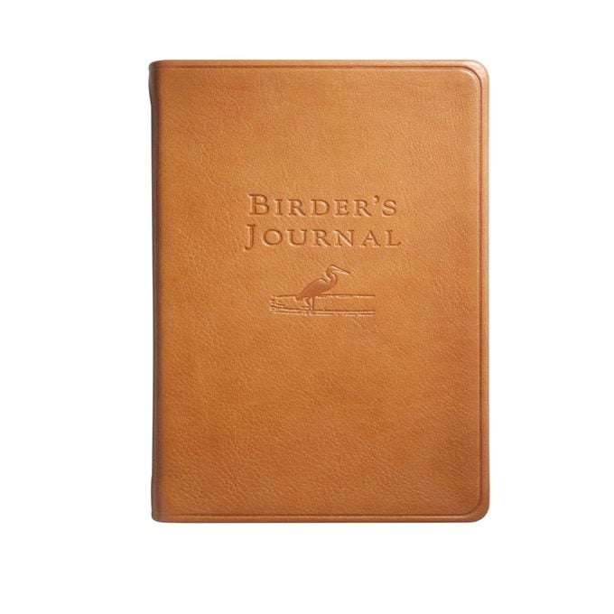 A tan leather-bound journal with a stamped bird on the cover.