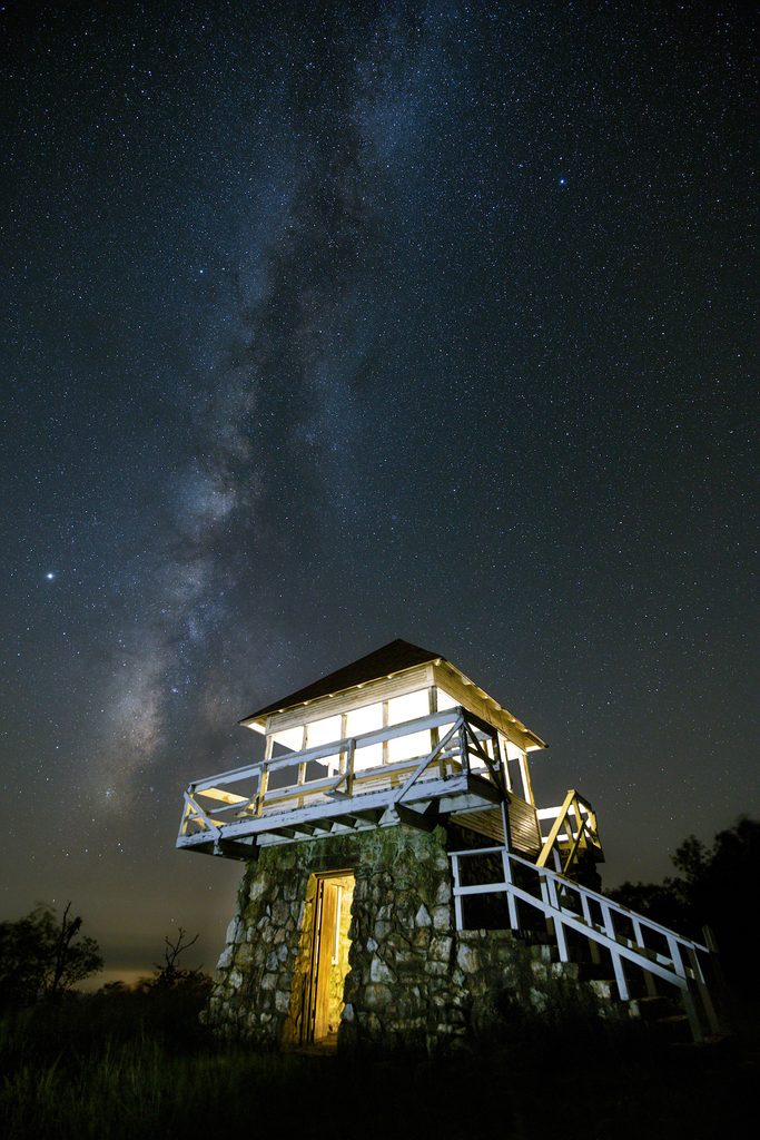 A night view of a fire tower and the milky way in Ouachita State Park.