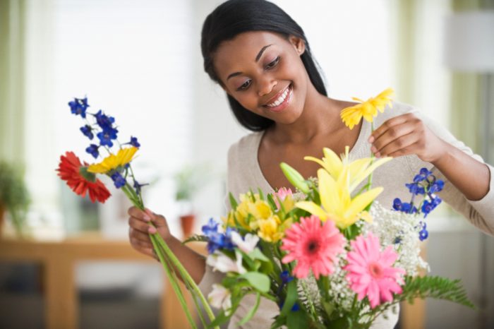 African American woman arranging fresh cut flowers