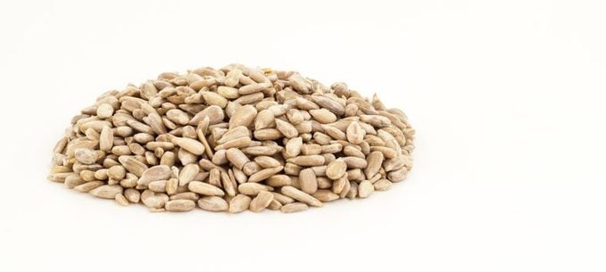 Close-Up Of Sunflower Seeds Against White Background