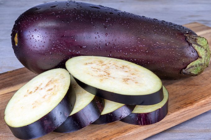 Slices of eggplant on wooden background