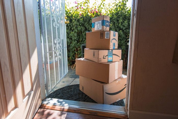 pile of amazon boxes outside a front door