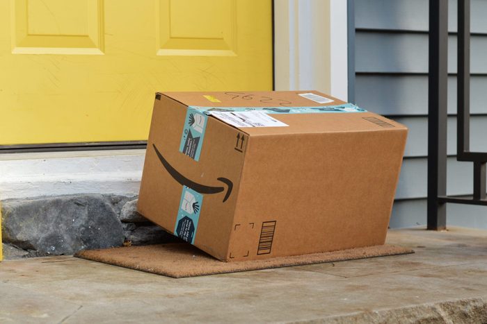 amazon package on a front porch with a yellow door