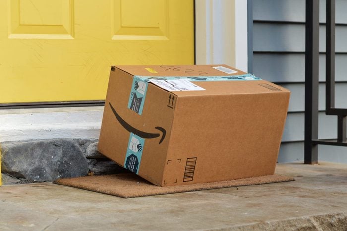 amazon package on a front porch with a yellow door