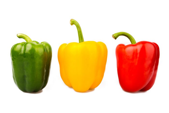 Green, yellow and red bell peppers isolated on white background