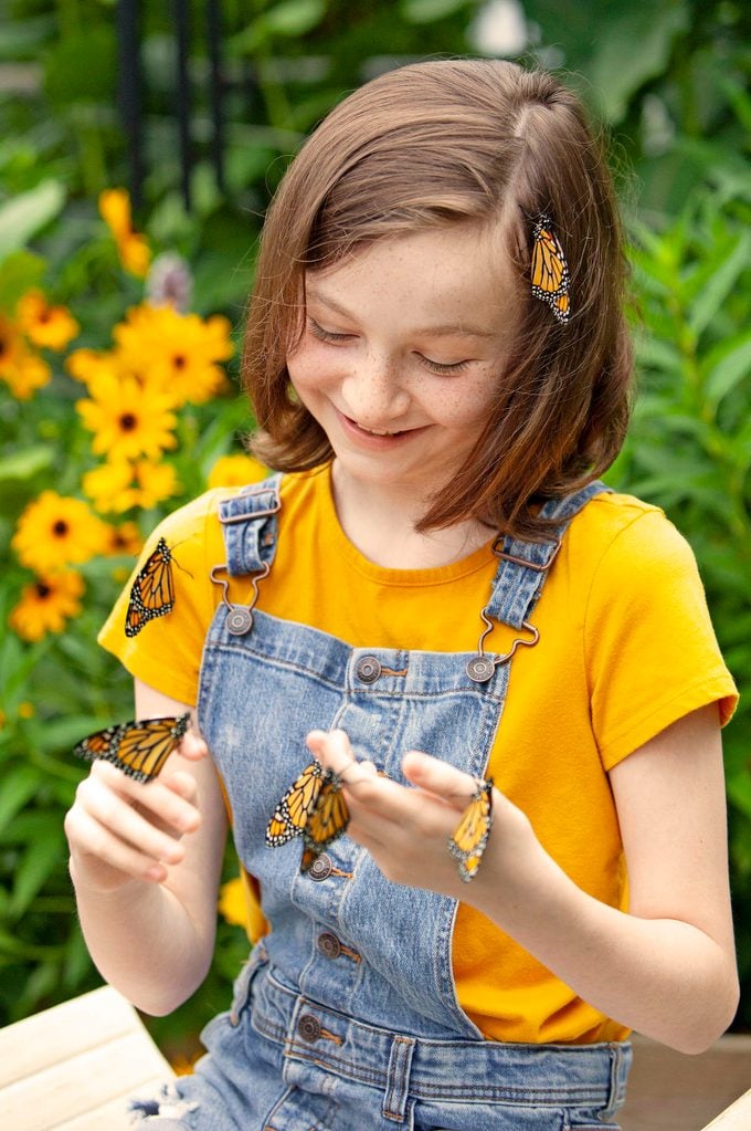Young girl with monarch butterflies on her