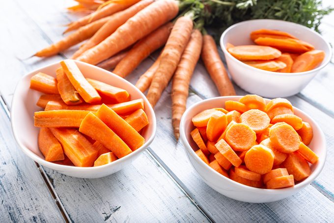 Fresh carrot and carrots slices on table.