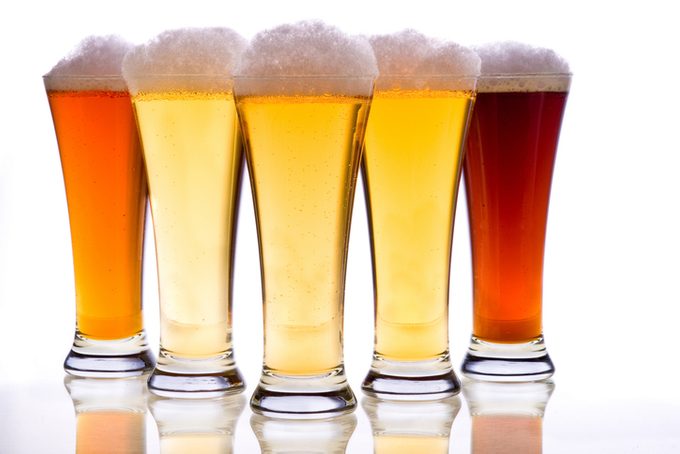 Close-up of beer glasses against white background